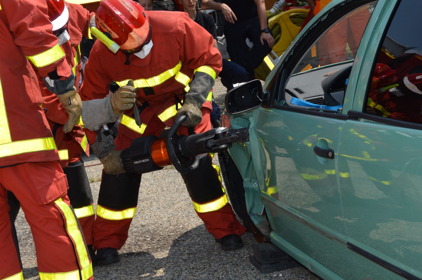 Firefighters cutting open a crashed car with hydraulic rescue tools