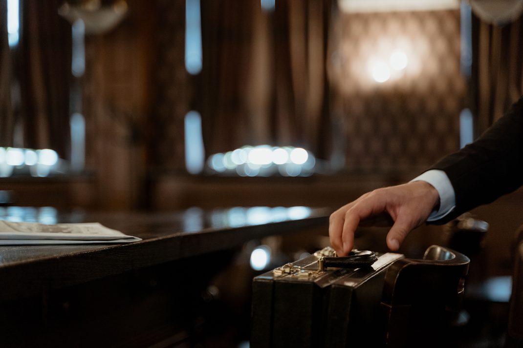 An attorney reaching for a briefcase in a courtroom