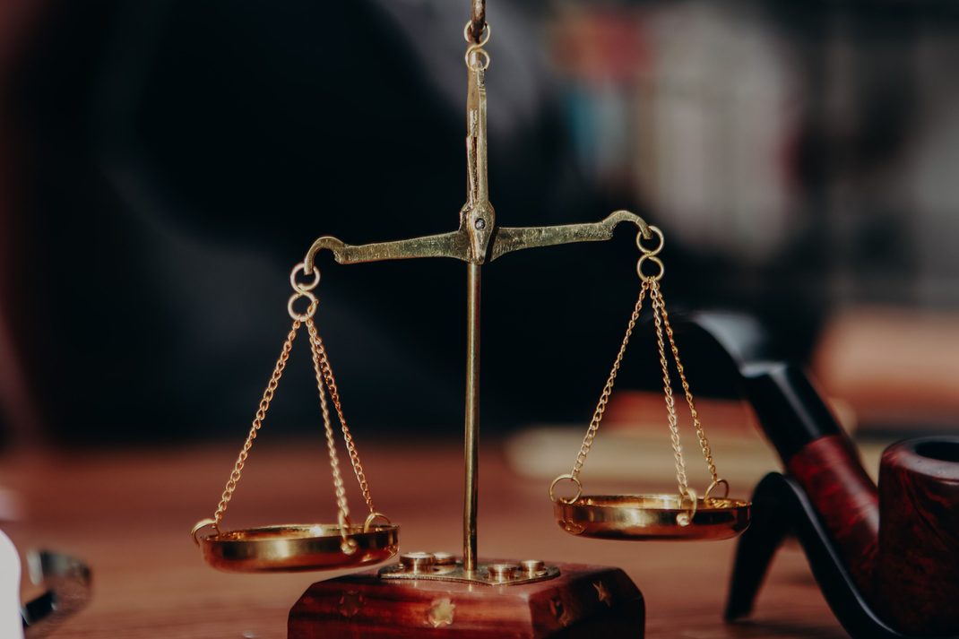 Brass scales of justice on a desk in a law office